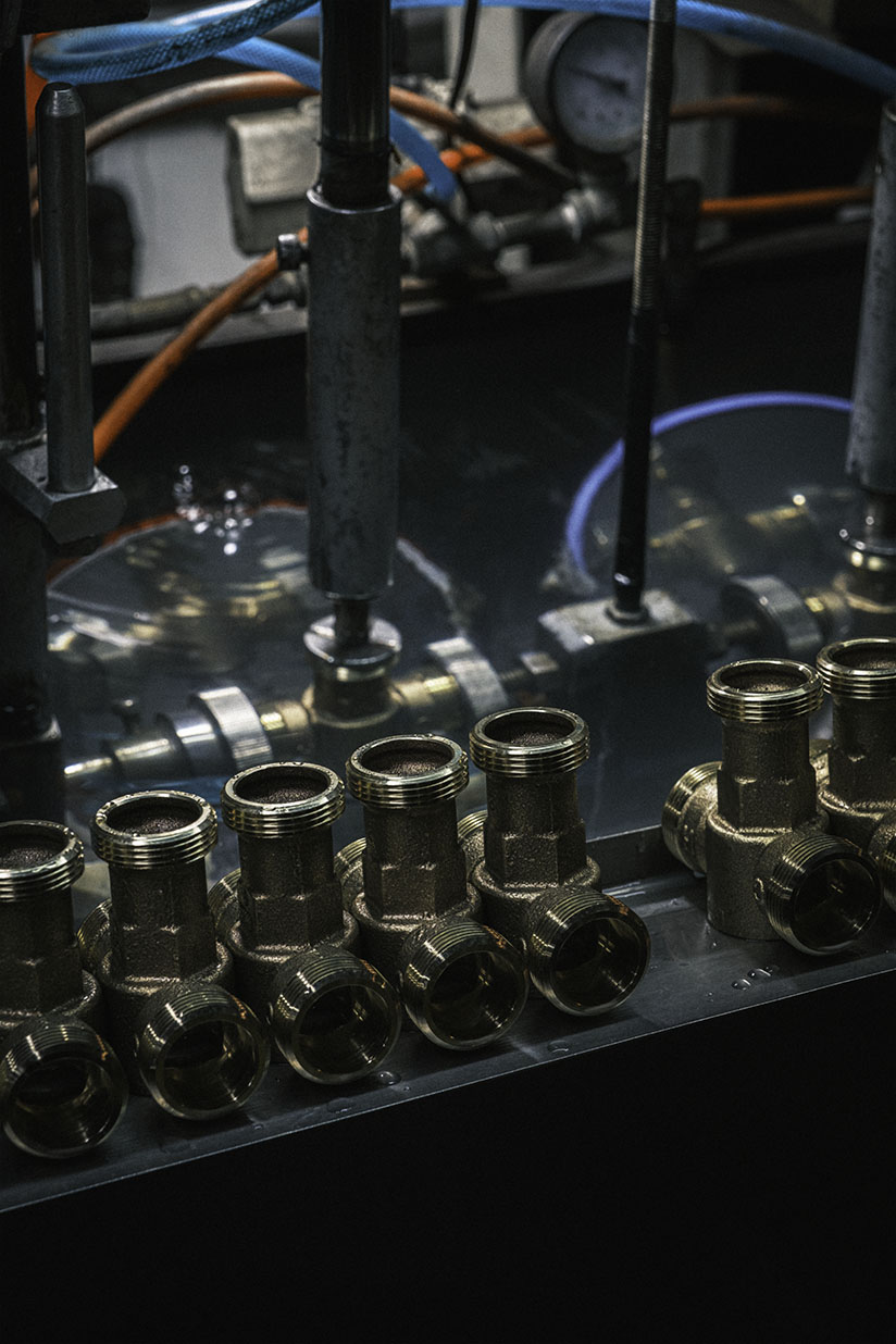 Bronze thermostatic mixing valve bodies on the production line at LINS Valve, machined and ready for assembly and pressure testing